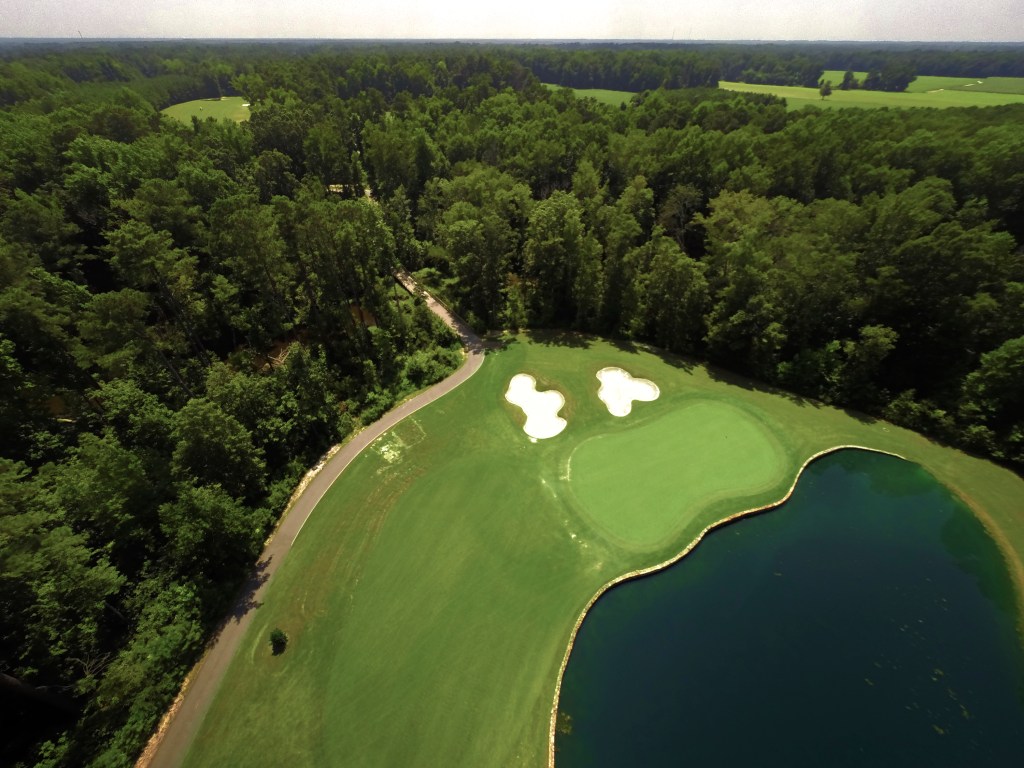 aerial view of golf course with pond and bunkers