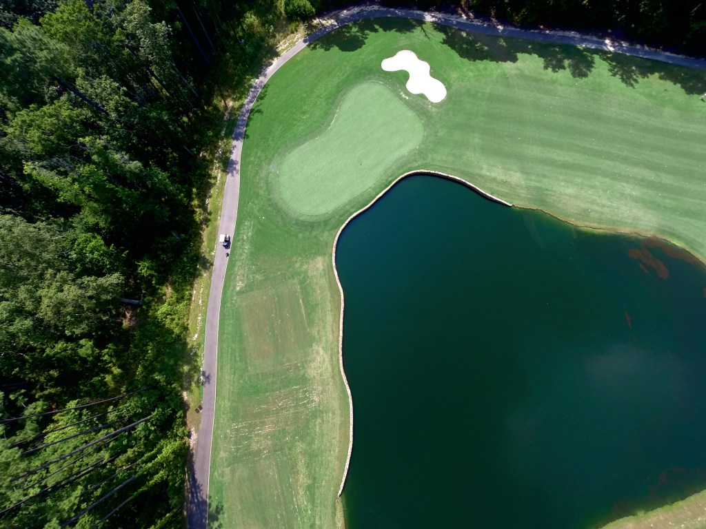 Aerial view of pond with bunker on golf course