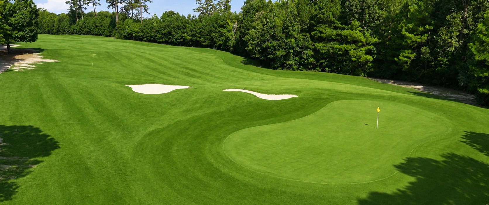 Aerial view of a green at Belmont Lake Golf Club in Rocky Mount, North Carolina, with two sand bunkers and surrounding trees.