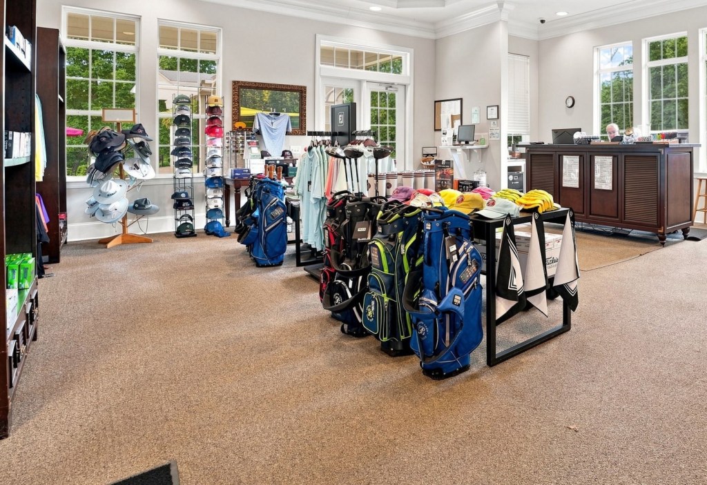 Belmont Lake Golf Club pro shop with a rack of golf bags, wall of caps and hats, and checkout counter